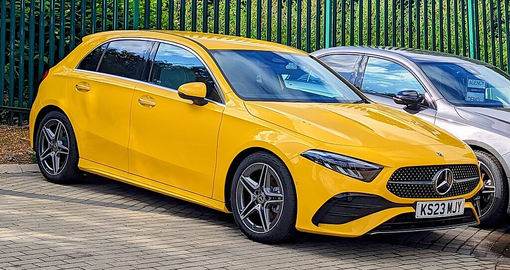 Mercedes-Benz A200 iz 2023. godine u žutoj boji, parkiran na otvorenom, s jasno vidljivim sportskim AMG dizajnom i modernim linijama karoserije.